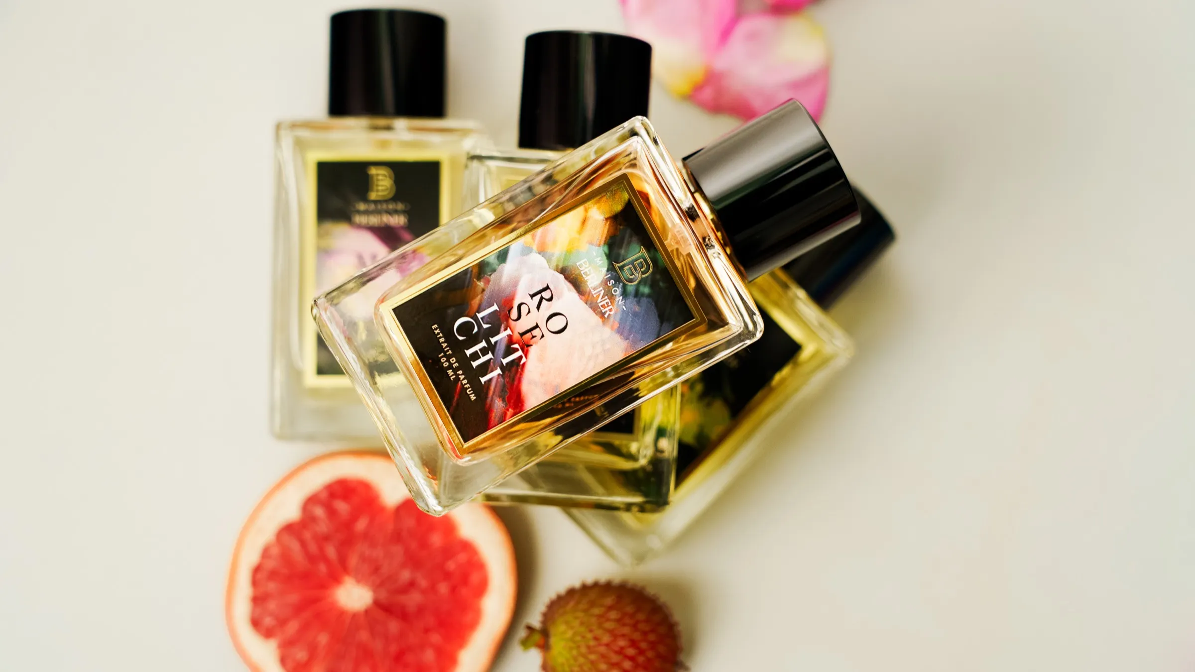 Rose litchi entouré des coffrets et flacons de Maison Berliner