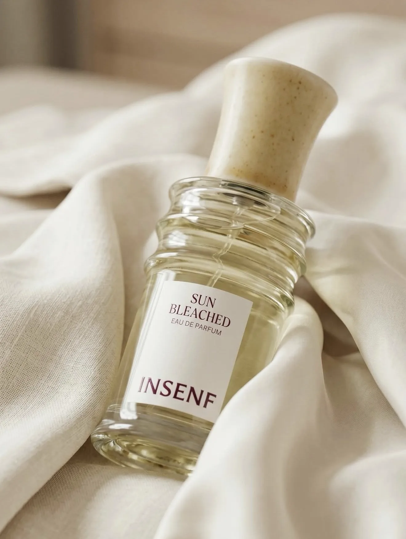 Sun Bleached, INSENF — flacon posé sur du lin froissé